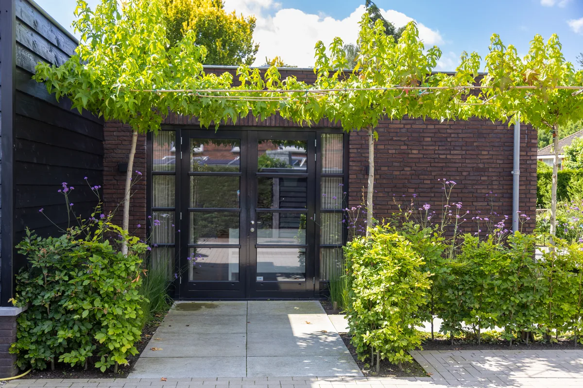 Entree van ’t Klijnhuysje met groene beplanting