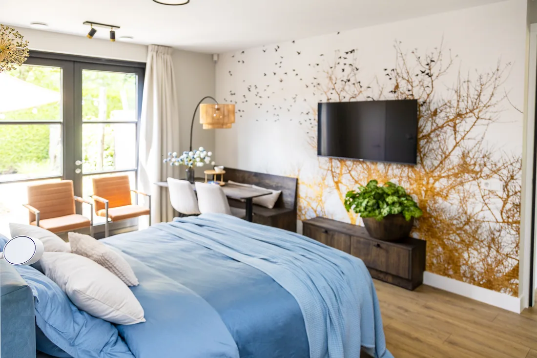 Slaapruimte met lichtblauw bed en warme details